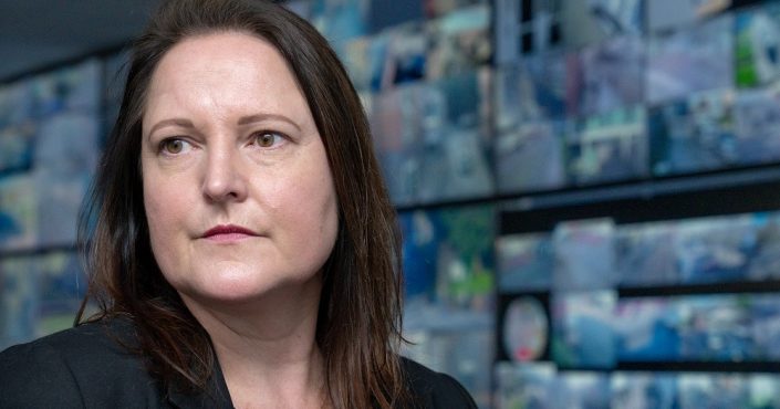 Police and Crime Commissioner Alison Hernandez looking away from the camera in front of multiple CCTV images on alrge screens at the CCTV control room in Exeter