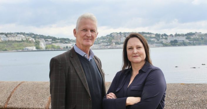 Mark Kingscote with Police and Crime Commissioner Alison Hernandez standing by a sea wall with a view of Torquay in the background