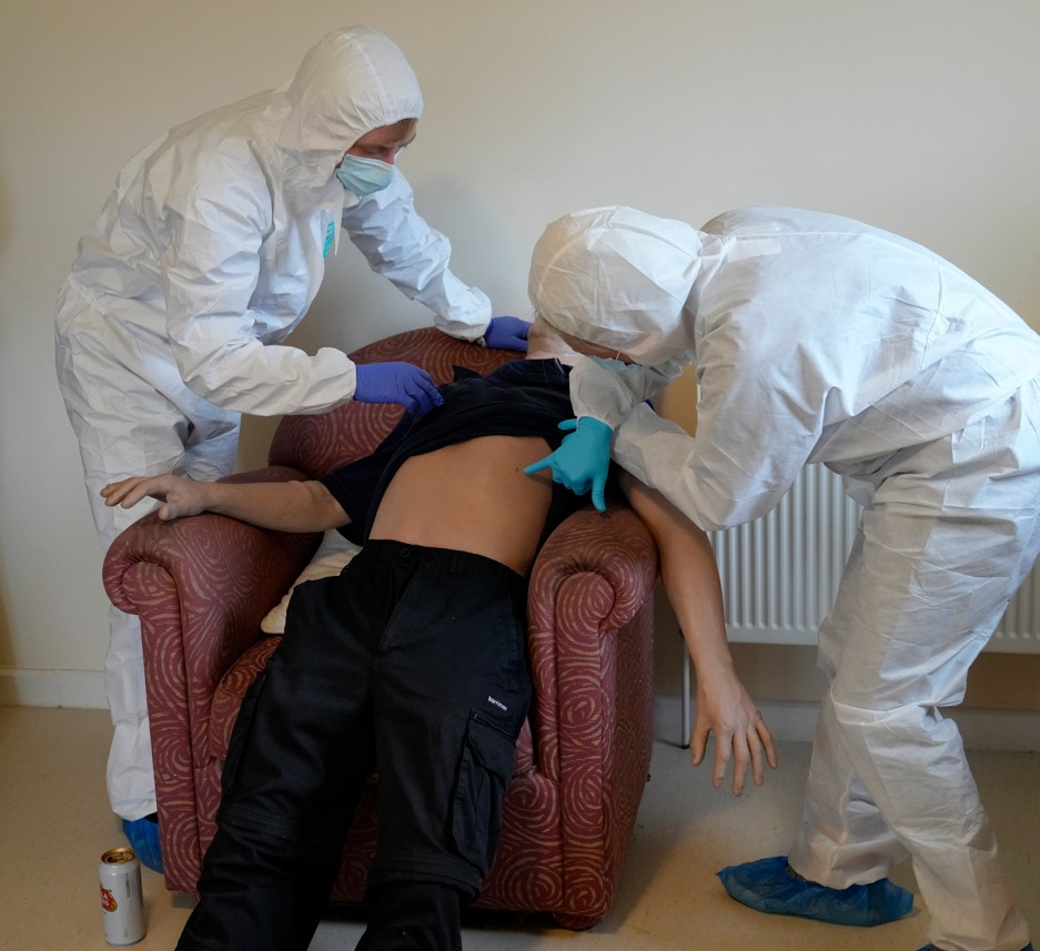scene Students investigating a 'death' at a mock crime scene posed by a mannequin
