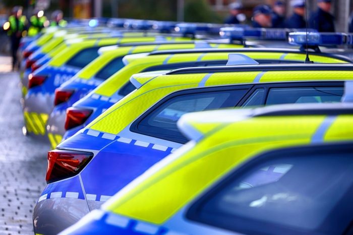 A,Yellow,And,Blue,Police,Car,In,The,Parking,Lot.