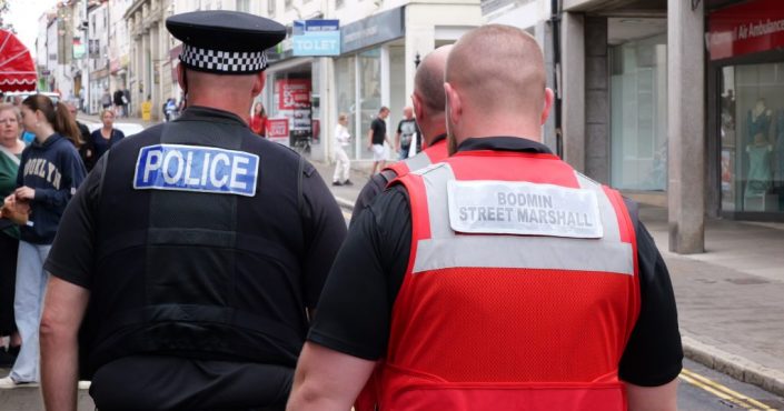 A street marshal on patrol in Bodmin, Cornwall, with a policeman
